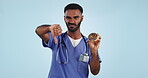 Thumbs down, donut and advice with a nurse man in studio on a blue background for healthcare consulting. Portrait, medical and reject sugar with an unhappy medicine professional looking negative