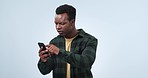 Confused, reading information and a black man with a phone on a studio background for confirmation. Doubt, thinking and an African person with a mobile for a problem, news or communication on media