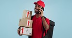 Man, logistics and courier with cellphone in communication to client, delivery or boxes in studio. Indian person, supply chain and cargo in conversation with customer, packages and blue background