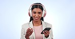 Woman, listening and headset with phone in studio on blue background in mockup for podcast, streaming service or music. Indian, person and face with dance, impressed or options on digital, web or app