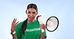 Volunteer woman, megaphone and speaker in studio for help, recruitment or call to action by blue background. Girl, community service and rally for social responsibility, job and smile on face at NGO