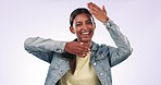 Hands, comic and the funny face of an indian woman in studio on a gray background for emoji expression. Portrait, smile and emotion with a happy young model in trendy clothes for fashion or style