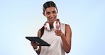 Fitness, tablet and a woman coach pointing at you in studio on a blue background for membership signup. Portrait, smile and a happy young personal trainer looking at her gym routine schedule