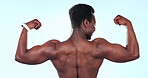 Strong, muscle and black man flex biceps, bodybuilder in studio with back view and fitness on blue background. Exercise, training with bodybuilding champion, power with pride and wellness in studio