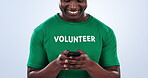 Volunteer hands, phone and happy black man typing charity search on website, community service blog or nonprofit homepage. Smartphone, studio and activist text NGO campaign contact on blue background