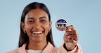 Hand, woman and badge for vote, usa election and support in studio on blue background with happiness. Politics, person and voting pin for government, freedom and choice or decision on mock up space