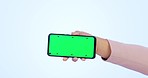 Person, hand and phone with green screen in marketing or advertising against a studio background. Closeup of mobile smartphone display, tracking markers or app on mockup space for advertisement