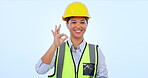 Engineering, happy woman and okay hands in studio success, building achievement and industry excellence. Face of asian builder or construction worker with yes or perfect emoji on a blue background