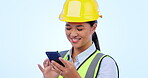 Engineering, woman and phone for construction chat, communication and project management in studio. Asian contractor or builder typing on mobile for architecture design update on a blue background
