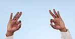 Ok, hands and person with sign for yes in studio or emoji for thank you, review and agreement in business mockup. Blue background, symbol and gesture icon for success, satisfaction and feedback