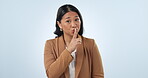 Studio, secret or face of woman with mystery, gossip or company privacy on blue background. Finger on lips, news or whisper with worker or shush gesture for rumor, drama or silence in business or job