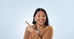 Business woman, point and smile in studio, face and space for choice, vote or review by blue background. Asian entrepreneur, happy and hand sign for decision, feedback or sale with mockup in portrait