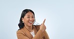 Asian business woman, point and studio with smile on face by space for choice, vote or review by blue background. Entrepreneur, happy and hand sign for deal, feedback or sale with mockup in portrait