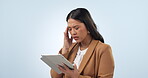 Business woman, headache and stress on tablet for stock market, financial mistake or thinking of bad investment. Asian trader with depression or regret for trading decision on blue, studio background