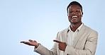 Happy black man, pointing and palm in marketing or advertising against a blue studio background. Portrait of African businessman showing deal, information or promotion for product on mockup space