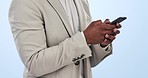 Business man, phone text and hands typing from social media and web networking in a studio. Male entrepreneur, professional and app for work with online website post and scroll with blue background