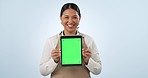 Happy asian woman, tablet and green screen in advertising, marketing or cafe against a studio background. Portrait of female person or small business waitress showing technology app display or mockup