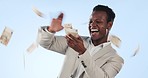 Happy black man, money rain and cash in financial freedom, winning or lottery against a studio background. African businessman blowing cash, dollar bills or paper notes in finance growth or profit