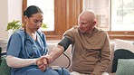 Woman, doctor and blood pressure machine in elderly care for heart beat, monitoring or healthcare at home. Female person, nurse or medical caregiver checking senior patient bpm or results at house