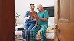 Tablet, nurse and senior man in bedroom, talking and consultation in nursing home. Tech, elderly person with a disability on bed and caregiver in conversation, help and healthcare results or report