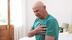 Sick, senior man and heart attack with pain, cardiovascular healthcare and risk of hypertension in bedroom at home. Elderly pensioner massage chest for heartburn, indigestion and medical emergency 