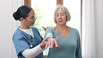 Physiotherapist, woman and patient in consultation by clinic by stretching of arm for pain. Elderly person, female nurse and rehabilitation for diagnosis, care or trust by talking in examination room