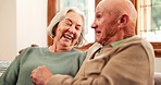 Senior couple, laugh and talking in home with love, care or discussion together in happy marriage in living room. Elderly man, old woman and chat about funny conversation, joke or relax in retirement