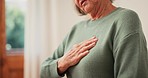 Senior woman, hands and heart attack with pain, cardiovascular healthcare and hypertension risk at home. Closeup, sick elderly lady and massage chest for heartburn, indigestion and medical emergency 