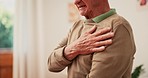 Hands, senior man and heart attack with pain, cardiovascular healthcare and risk of hypertension at home. Closeup, elderly and massage chest for heartburn, indigestion and medical emergency of stroke