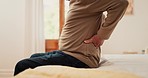 Hands, man and pain in home from back, muscle injury or risk of fatigue for scoliosis in bedroom. Closeup, bad posture and stretching spine for fibromyalgia, osteoporosis and healthcare for arthritis