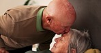 Bed, kiss forehead and senior couple for support, bonding and compassion at home for rehabilitation. Retirement, marriage and elderly man care for woman with illness, healing and recovery in bedroom