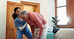 Recovery, help or assistance with a nurse and old man on a sofa in the living room of his retirement home. Back pain, rehabilitation and a young woman volunteer with a senior patient in his house