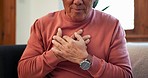 Hands, heart attack and senior man on sofa with lungs, problem or breathe, risk or emergency closeup. Chest pain, zoom and elderly person with anxiety, asthma or heartburn, stress or panic in a house