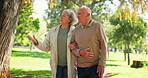 Senior, couple and walking or talking in park with pointing, conversation and bonding for retirement. Elderly, man or woman outdoor in nature with communication, love and discussion for relax or date