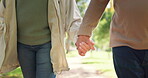 Love, couple holding hands and walking at park, care and trust together in garden. Closeup, support and man and woman in nature for healthy relationship, connection or loyalty in marriage commitment