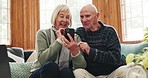 Phone, search and happy senior couple on a sofa with social media, chat or reading at home together. Smartphone, app and old people in a living room with online communication, retirement and bonding