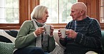 Love, coffee and senior couple on a sofa speaking in a living room relax, bond and communication at home together. Tea, break and old people with gossip, conversation or retirement chat in a house