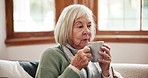 Coffee, thinking and senior woman relax on a sofa peaceful, calm or having a quiet morning in her home. Face, break and elderly lady person with tea in a living room resting or enjoying retirement