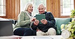 Tablet, conversation and senior couple on a sofa networking on social media, mobile app or the internet. Happy, discussion and elderly woman and man in retirement scroll on digital technology at home