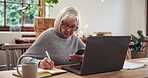 Senior, woman and writing with phone and laptop for planning, investment or schedule for retirement in living room. Elderly, person or notebook with technology and research at table in lounge of home