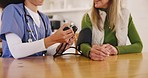 Healthcare, blood pressure and nurse with elderly woman at table in apartment for test. Retirement, senior care and old person with caregiver checking health for hypertension in house or nursing home