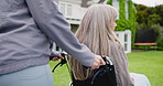 Hands, wheelchair and an old woman with her daughter in the garden of a retirement home for a visit. Nurse, volunteer or caregiver and a senior patient with a disability outdoor for a walk together