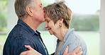 Senior couple, hug and love with forehead kiss in home in retirement with marriage bonding, care and support. Trust, elderly woman and man in living room with embrace and relax with commitment