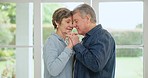 Senior couple, hug and happy dancing in a home in retirement and marriage with love, care and support. forehead kiss, elderly woman and man in a living room with embrace and relax with commitment