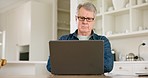 Laptop, serious and senior man in home at kitchen table, reading email or news on technology. Computer, typing and elderly person on pc for social media, remote work or internet search in retirement