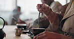 Woman, hand and pouring of black tea in cafe to enjoy for delicious, hot and beverage in winter. Female person, cup and kettle for steam for brewing of peaceful, calm or relaxing drink in coffee shop