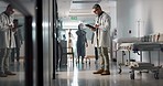 Doctor, man and tablet with reading, corridor and planning for surgery, advice or check in hospital. Medic, touchscreen and typing with contact, app or brainstorming for medical innovation in clinic