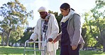 Senior woman, walker and caregiver outdoor in garden, park or nature with support for exercise, wellness or walking. Elderly care, happiness and person walk with nurse, help and frame in retirement