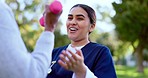 Fitness, nurse and hand with dumbbell for exercise, wellness and physiotherapy outdoor at park with smile. Caregiver, person and workout, training or physical therapy for healthy body and happiness