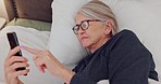 Phone, relax and senior woman in bed networking on social media, mobile app or the internet. Communication, technology and elderly female person in retirement scroll on website with cellphone at home